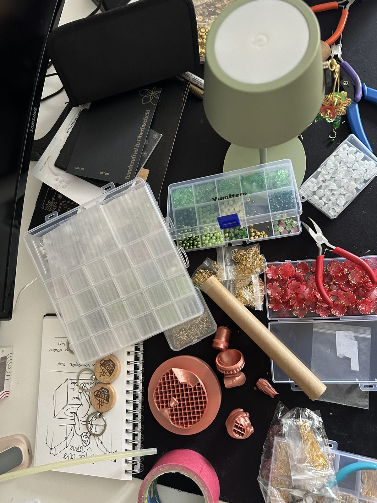 Chaotischer Arbeitstisch mit Perlenboxen, Zangen und Draht
