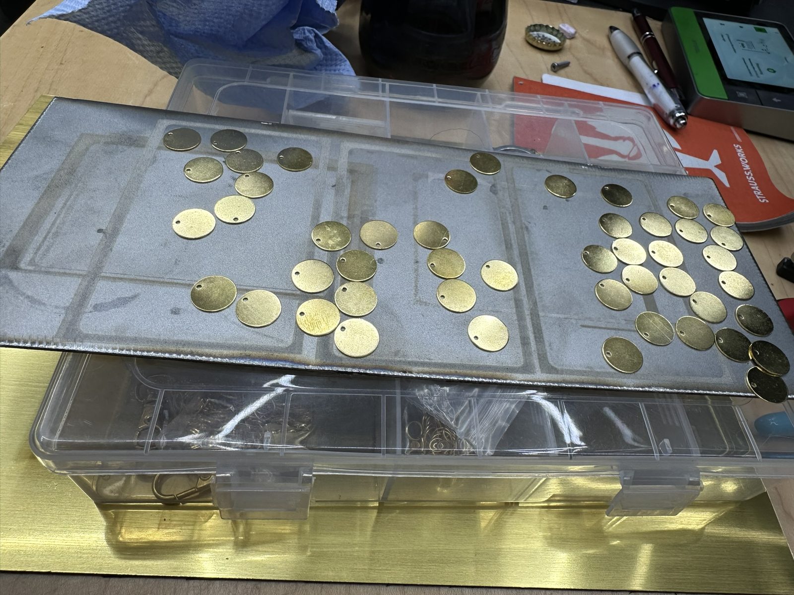 Messing-Rohlinge in einer Sortierbox auf dem Lasertisch