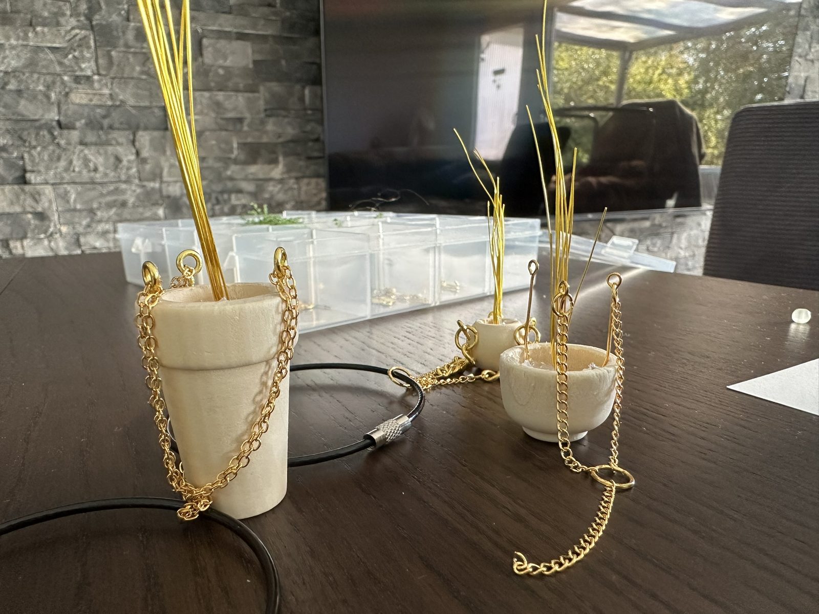 Kleine Töpfchen mit goldenem Draht auf dem Arbeitstisch