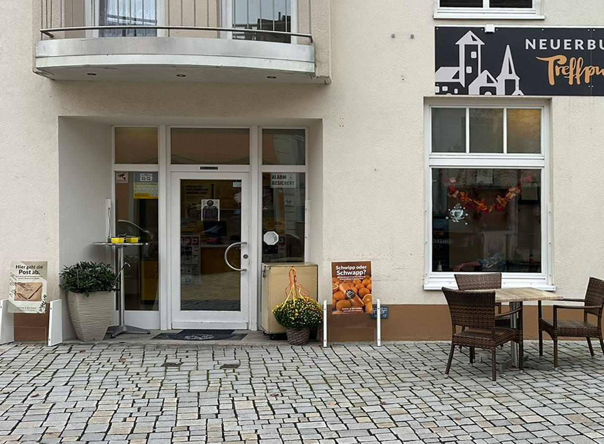 Eingangsbereich des Treffpunkts mit Plakat und Postschild