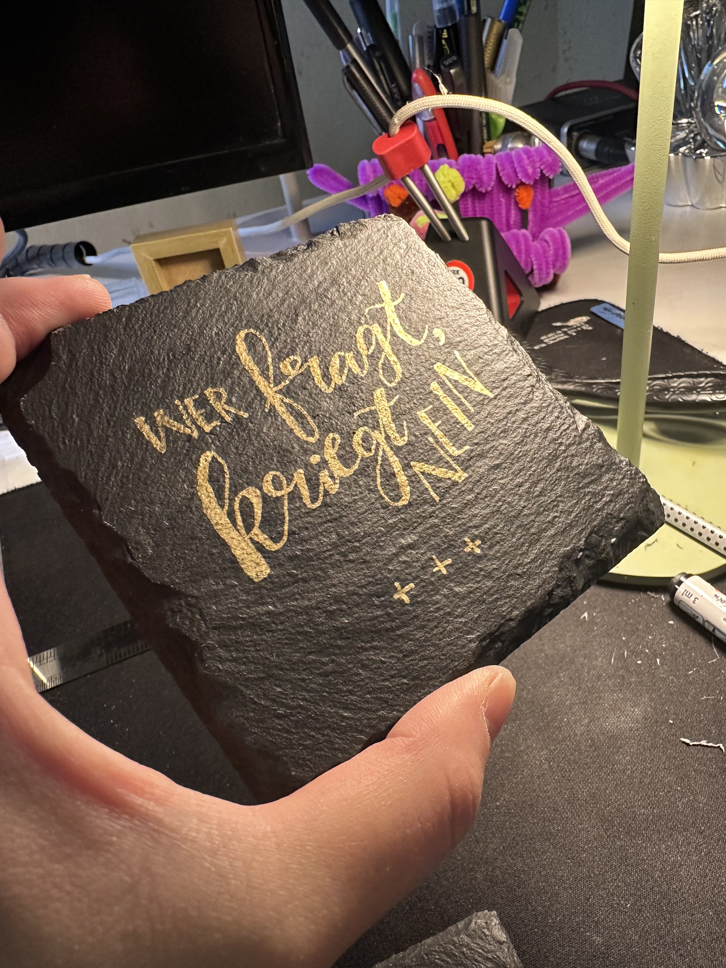 Werkstattfoto: Lackstift und Lasergravur auf Schiefer