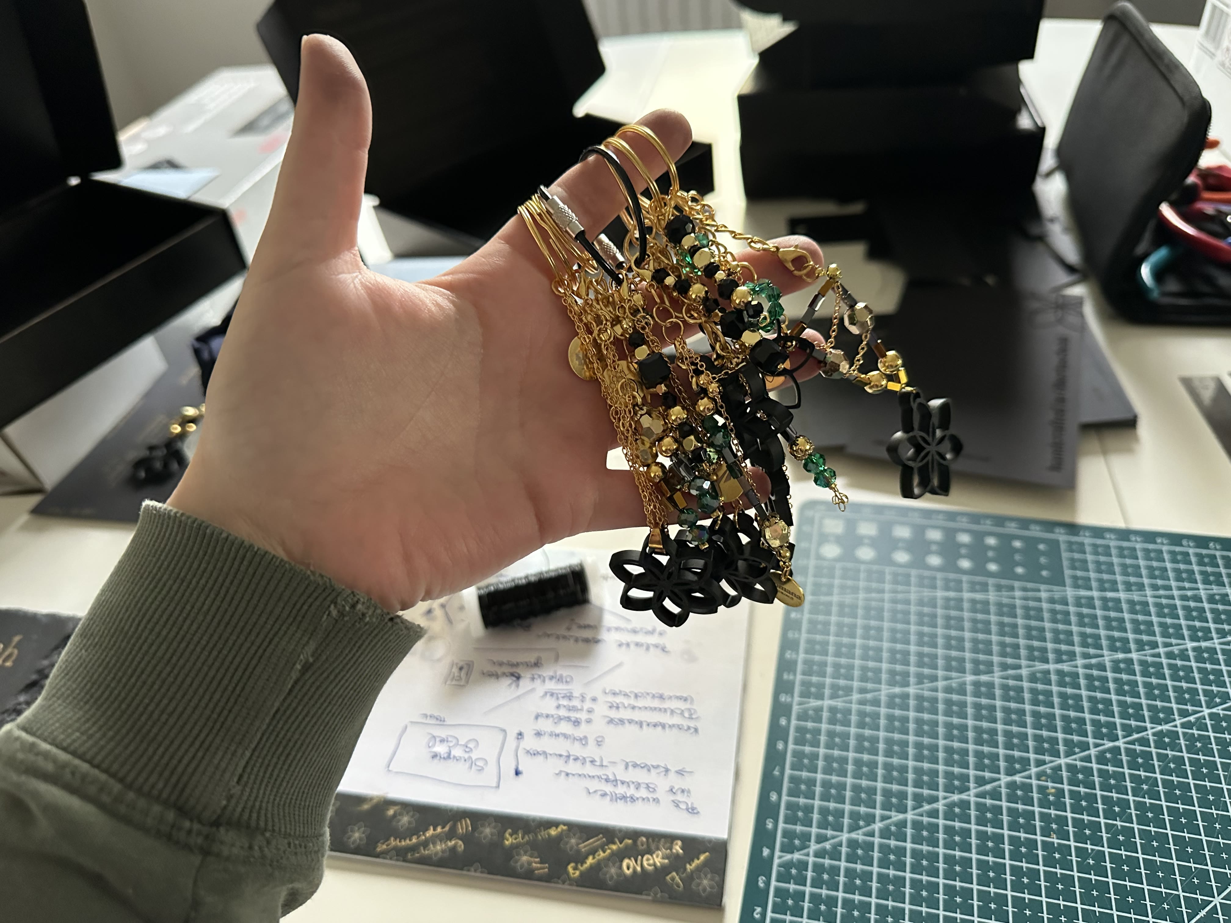 Eine Handvoll fertiger Schlüsselanhänger mit Perlen, Ketten und 3D-gedruckten Blüten